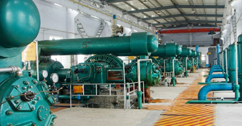 Conventional power piston air compressor installed at industrial user site — multi-unit reciprocating compressor arrangement for large-scale pneumatic tool and process air supply at 0.8 MPa