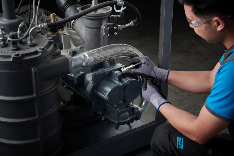 Certified technical engineers performing precision maintenance on oil-free air compressor machinery